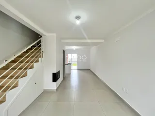 Hall de entrada com escada e corredor em um imóvel moderno.