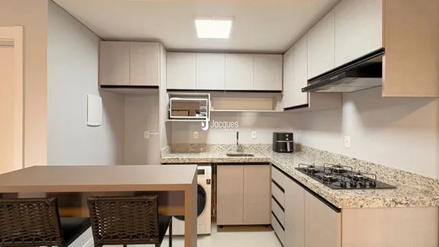 Foto de uma cozinha com armários brancos e bancadas claras.