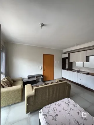 Sala de estar com sofá e cama em ambiente claro.