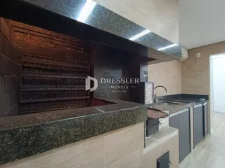 Detalhe de uma área de cozinha com revestimento de pedra escura e armários modernos.