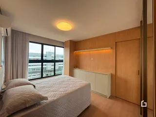 Quarto com cama e armário de madeira em um apartamento.