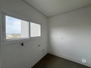 Vista interna de um cômodo com janela e parede branca.