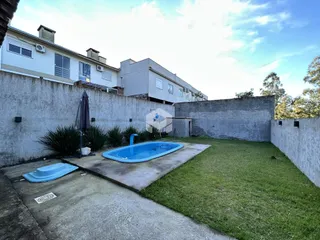 Foto da área externa com piscina e jardim de uma residência em Lajeado.