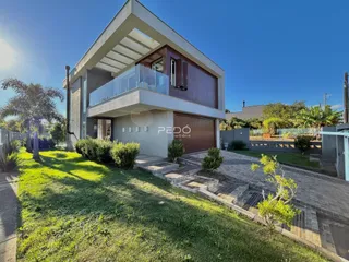 A fachada de uma casa moderna com garagem e varanda em Lajeado, Brasil.