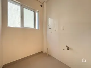 Vista interna de um corredor com parede branca e piso de cerâmica.
