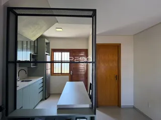 Vista interna de uma cozinha e área de passagem em um imóvel no Brasil.