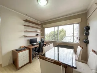 Ambiente de escritório com mesa de trabalho e estantes em um imóvel.