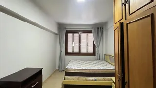 Quarto com janela e cama de casal em um apartamento.