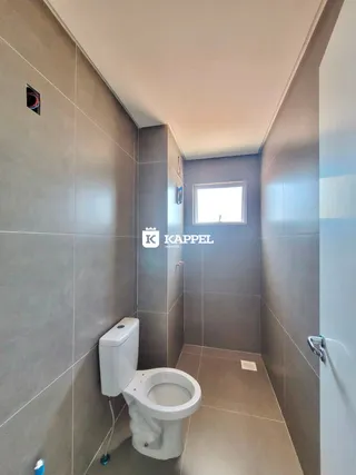 Foto de um banheiro com revestimento de azulejo cinza.