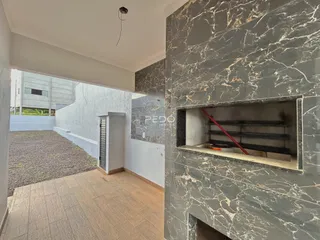 Ambiente interno com revestimento de mármore escuro e piso de cerâmica.