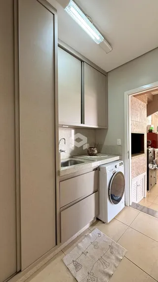 Foto de uma cozinha com armários e máquina de lavar roupa.