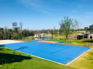 Vista externa de uma área gramada com uma superfície azul no quintal.
