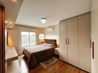 Quarto com cama grande e armários em um ambiente claro com piso de madeira.