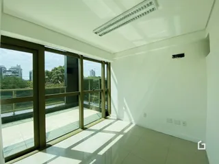 Interior com grandes janelas que dão para uma área externa.