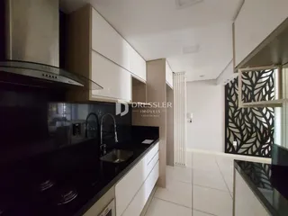 Foto de uma cozinha moderna com armários brancos e bancadas escuras.
