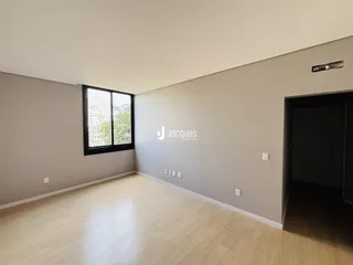 Sala de estar com piso de madeira clara e paredes cinzas.