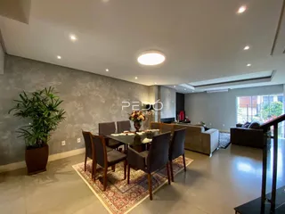 Sala de estar com mesa de jantar e sofá em um apartamento.
