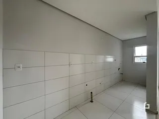 Vista interna de um corredor com paredes brancas e piso claro.