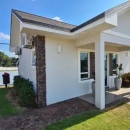 Fachada externa de uma residência branca com área de jardim em Lajeado, Brasil.