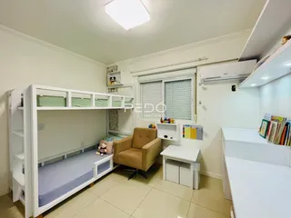 Quarto com cama de beliche e mobiliário branco no interior da residência.