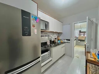 Cozinha moderna com armários brancos e bancadas escuras.