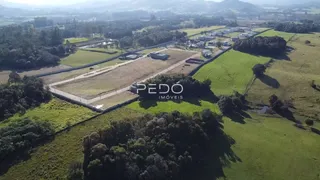 Vista aérea de uma propriedade rural com campos e vegetação ao redor.