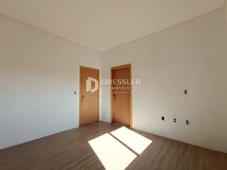 Vista interna de um cômodo com piso de madeira e portas de madeira.
