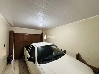 Vista interna de um corredor com portas de madeira e um carro estacionado.