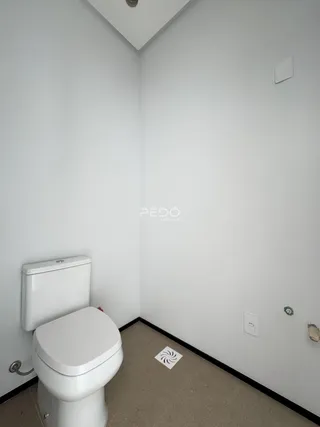 Foto de um banheiro interno com piso de carpete e paredes brancas.