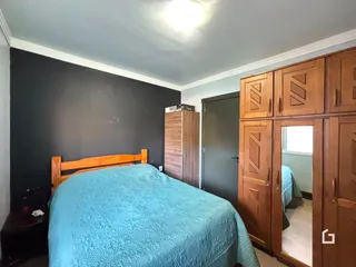 A foto mostra um quarto com cama de madeira e armários embutidos.