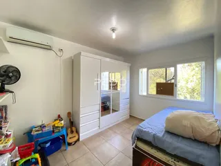 Quarto com armário branco e janela.