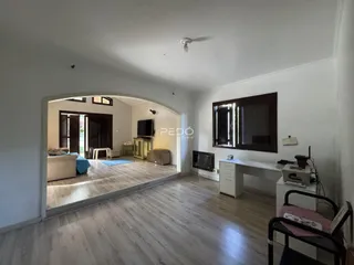 Sala de estar com piso de madeira clara e parede branca.