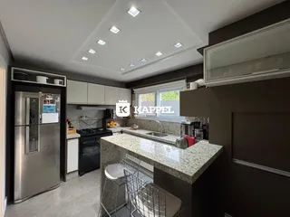Cozinha moderna com bancadas de granito e eletrodomésticos de aço inoxidável.