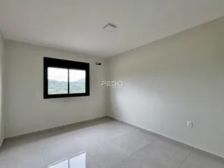 A sala apresenta paredes brancas e piso de cerâmica claro.
