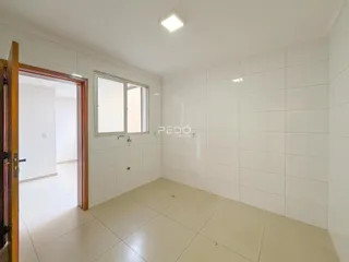 Vista interna de um corredor com paredes brancas e piso de cerâmica.