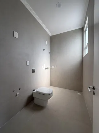 Foto de um banheiro com revestimento cerâmico e paredes brancas.