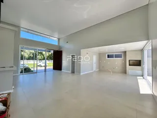 Ambiente interno amplo com piso claro e grandes portas de vidro.