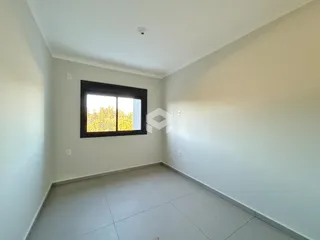 Uma sala de estar clara com piso de cerâmica e janela.