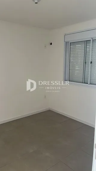 Interior de uma sala com piso de cerâmica e janela.