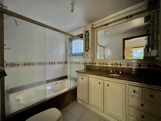 Banheiro com revestimento de azulejos brancos e marrons.