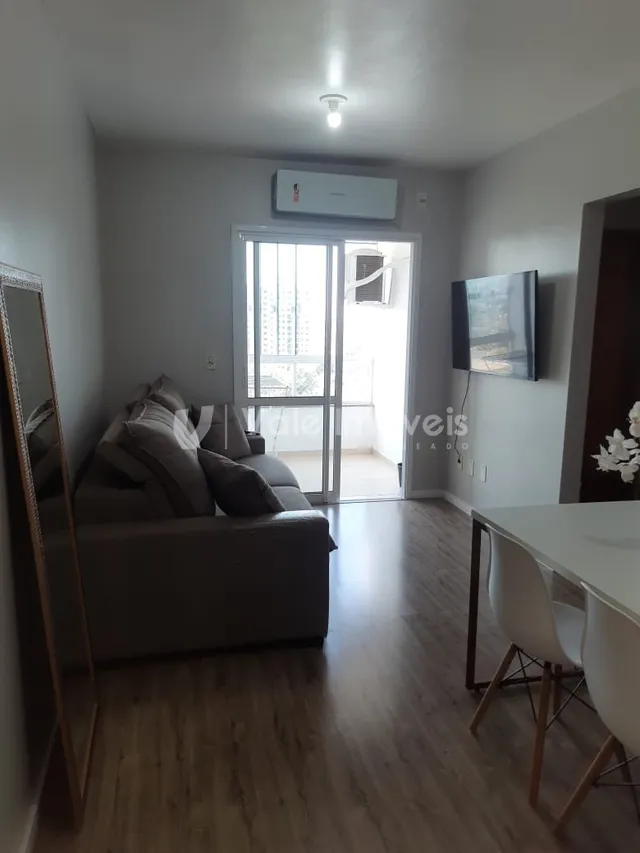 Sala de estar com sofá e piso de madeira clara.