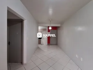 Um corredor interno com piso de cerâmica e paredes brancas é visível na propriedade.