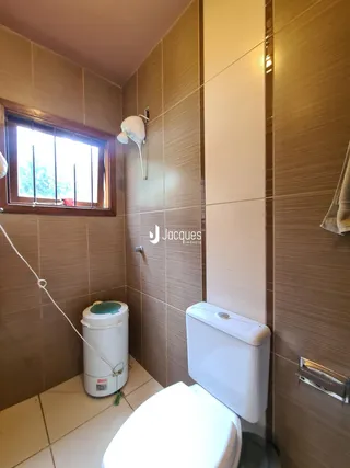 Foto interna de um banheiro com revestimento de cerâmica.