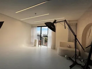 Sala de estar moderna com grandes janelas e iluminação clara.