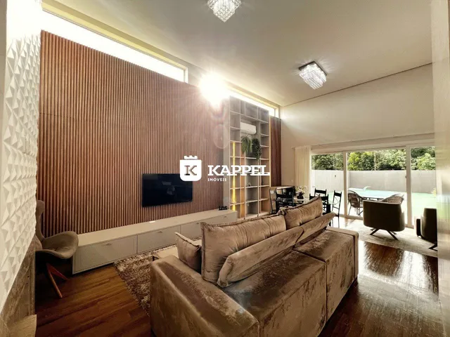 Sala de estar com sofá grande e piso de madeira.