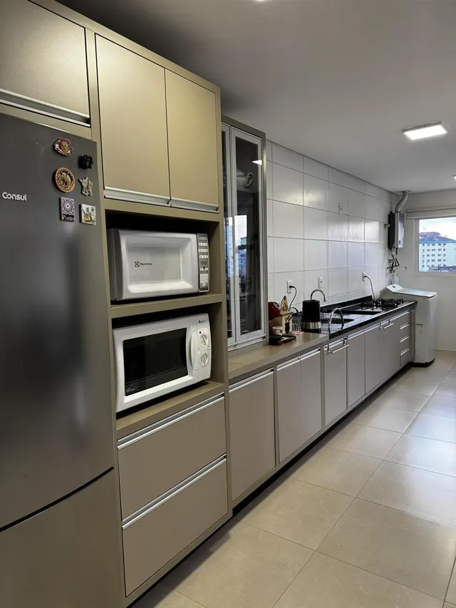 Vista da cozinha moderna com armários e eletrodomésticos em Lajeado.