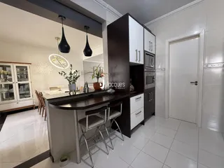 Vista de uma cozinha moderna com armários e bancada em Lajeado.