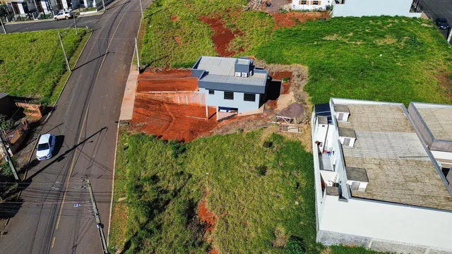 Vista aérea de uma propriedade em Lajeado, Brasil, mostrando uma construção com telhado metálico e terreno em desenvolvimento.
