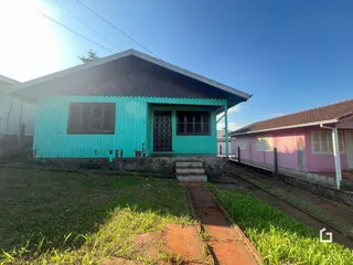 Fachada de uma casa em Lajeado, Brasil, com gramado e trilhos de trem ao lado.