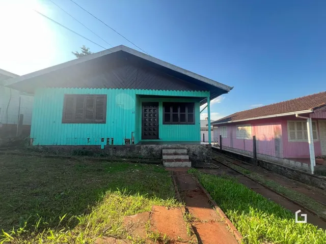 Fachada de uma casa em Lajeado, Brasil, com gramado e trilhos de trem ao lado.